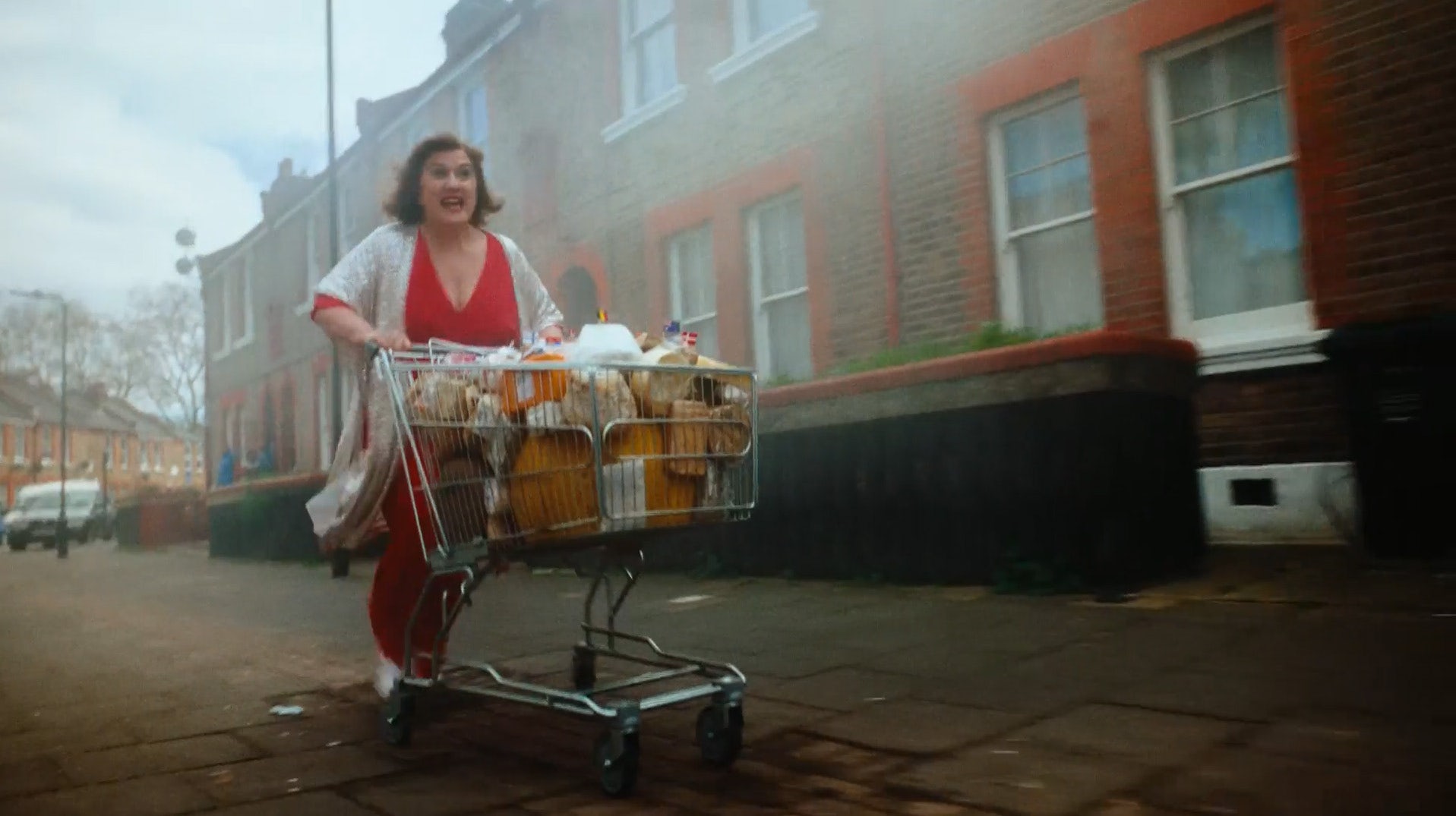 Still from BBC Eurovision 2023 ad showing a person running down a street pushing a trolley