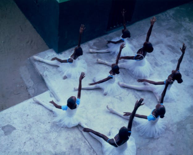 Aerial image by Gabriel Moses showing eight ballet dancers sat on the floor with their arms held out wide