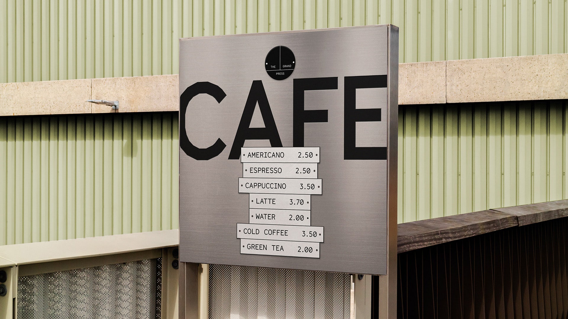Image shows a menu for the Grand Press cafe featuring a price list on a grey background
