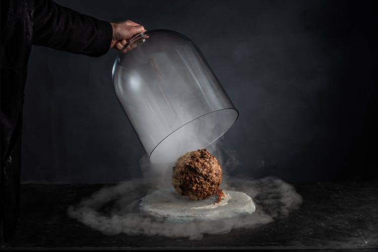 Image of the mammoth meatball being unveiled from underneath a cloche