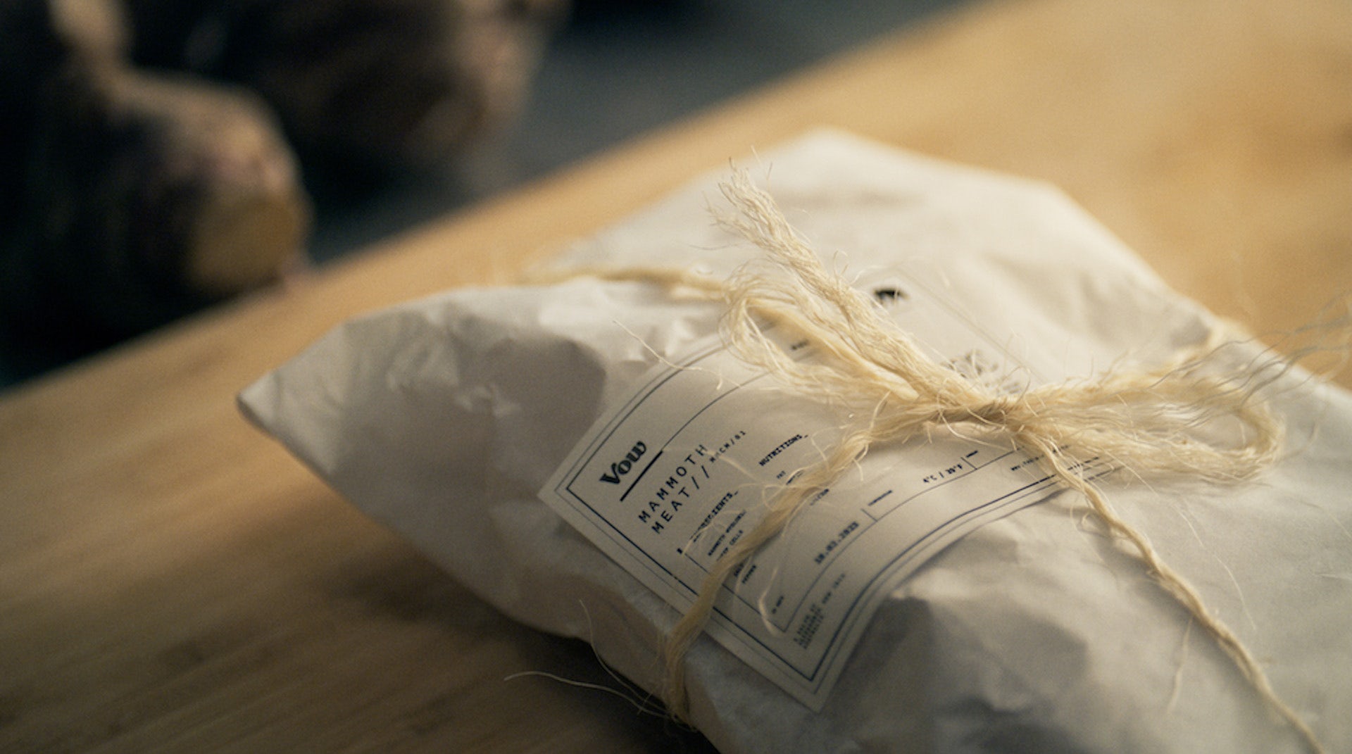 Image shows a white paper package tied with string containing Mammoth meat
