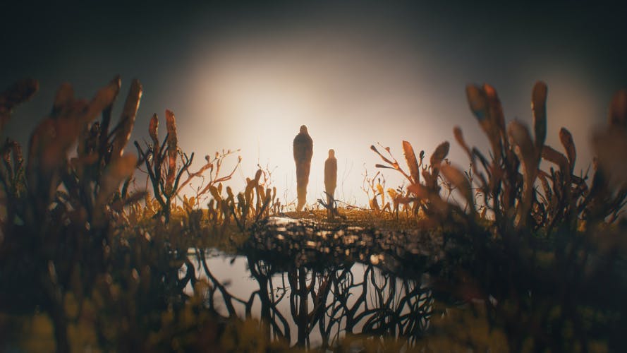 Still image from HBO TV series The Last of Us showing a lake, a landscape formed out of fungus, and two figures in the shape of humans